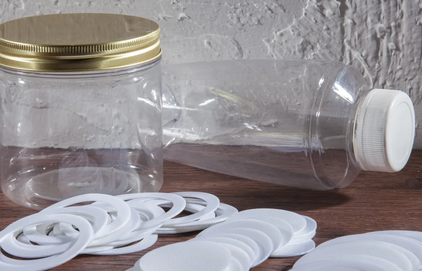 Die-cut closure liners and sealed jars on a worktable